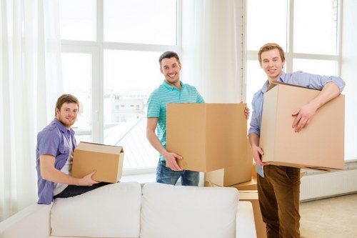 Local removals team handling boxes and furniture in an Ilford street