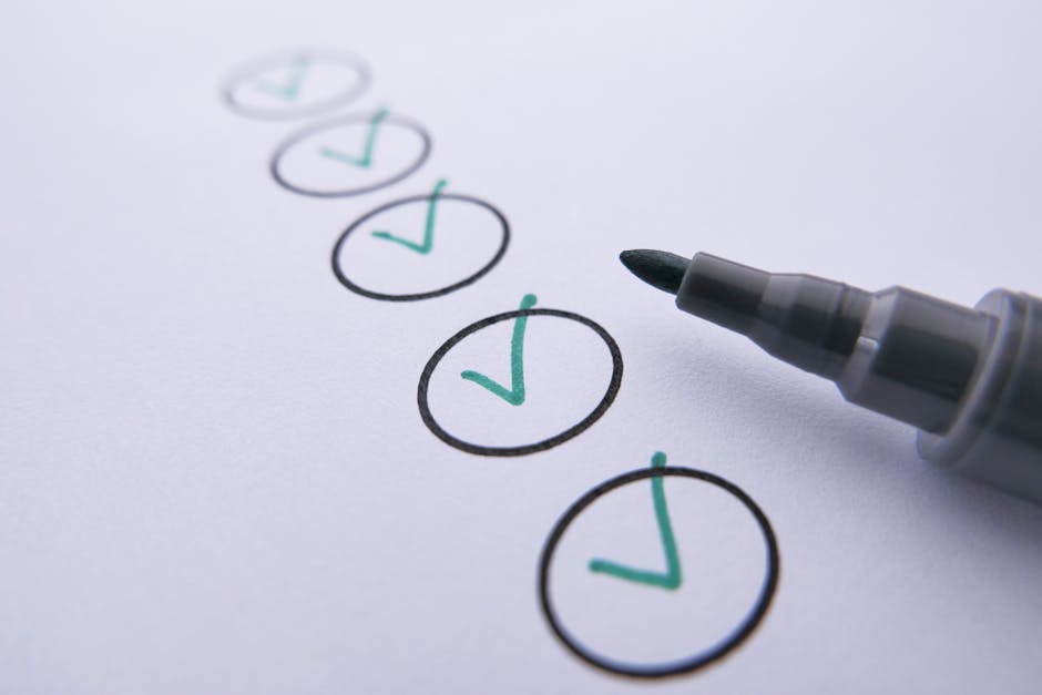 A close-up image of a white sheet of paper with seven black and green check marks inside hand-drawn circles, arranged vertically in a list format. A gray marker with a black tip is positioned on the right side of the paper, as if it has just been used to mark the check marks. The paper appears to be lying on a flat surface, and the lighting highlights the clarity of the check marks and the marker. This image visually represents the process of completing a checklist, which could relate to moving, packing, or office relocation tasks handled by Ilford Man and Van, as indicated by the context of house and office removals and logistics.